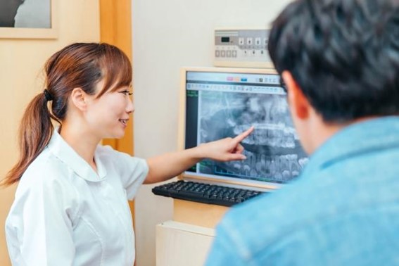 レントゲンを診ながら説明する歯科衛生士
